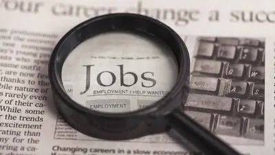 Zeitung mit Headline "Job" und einer Lupe darauf. Symbolisiert Jobsuche