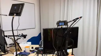 Moderationszimmers von Gerd Frera mit 3 Bildschirmen, Kameras, Notebook und Whiteboard